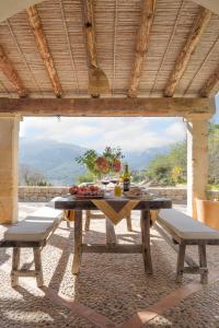 a picnic table with two benches under a roof at La Zalema in Esporles