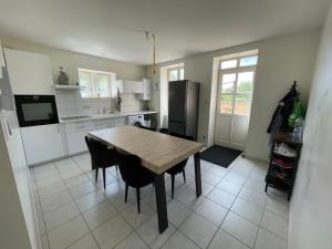 a kitchen with a wooden table and black chairs at Chambre privée - Maison partagée in Saint-Martin-Belle-Roche