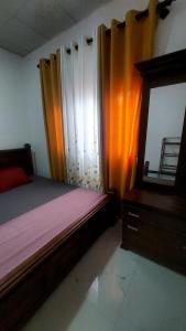 a bedroom with a bed and a dresser and a mirror at Pumpkin eco villa in Tangalle