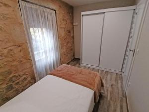 a small bedroom with a bed and a sliding door at Casa da Corna by Cristian&Tamara "alquileres" in Pobra do Caramiñal