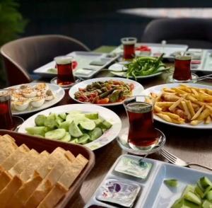 a table with many plates of food on it at COMFORT HOUSE HOTEL in Pelitli
