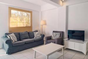 a living room with a couch and a tv at Villa Hera Periyali in Vasilikos