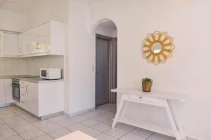 a white kitchen with a table and a microwave at Villa Hera Periyali in Vasilikos +14 photos