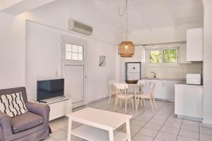 a living room with a couch a table and a kitchen at Villa Hera Periyali in Vasilikos