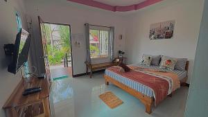 una camera da letto con un letto e una TV a schermo piatto di Kaija Resort a Ko Larn