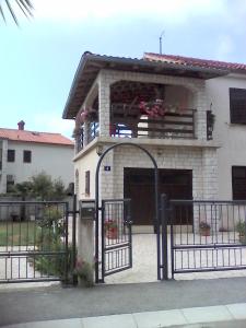 a house with a gate in front of it at Buba Apartment in Medulin
