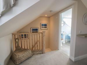 une pièce avec un escalier avec une chaise et une salle de bain dans l'établissement Arthur's Cottage, à Dumfries
