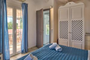 Un dormitorio con una cama azul y un balcón. en Villa Lito Periyali, en Vasilikos 16 fotos más