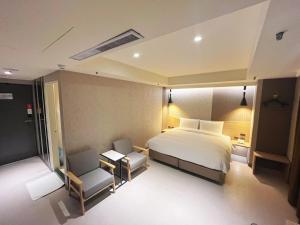 Rúm í herbergi á 新仕飯店-New City Hotel