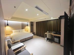Rúm í herbergi á 新仕飯店-New City Hotel