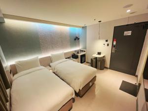 Rúm í herbergi á 新仕飯店-New City Hotel