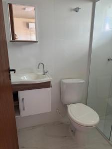 une salle de bain avec toilettes, lavabo et miroir dans l'établissement Residencial Lara 6, à Itapema 6 autres photos