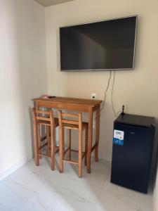 une table avec deux chaises et une télévision murale dans l'établissement Residencial Lara 6, à Itapema