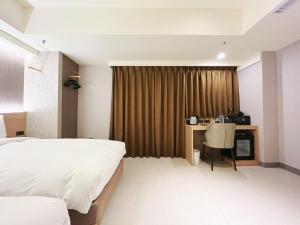 Rúm í herbergi á 新仕飯店-New City Hotel