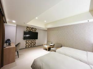 Rúm í herbergi á 新仕飯店-New City Hotel