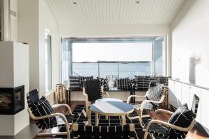 a room with chairs and a table and a large window at Hotel Rantapuisto in Helsinki