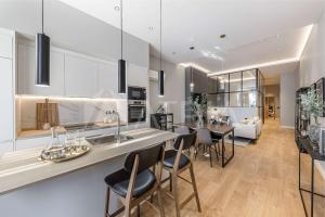 a kitchen and living room with a counter and chairs at Designer apartment 2 in Madrid +21 photos