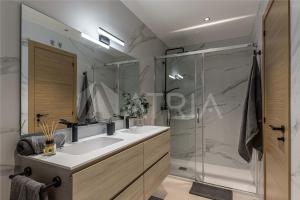 a bathroom with a shower and two sinks and a mirror at Designer apartment 2 in Madrid