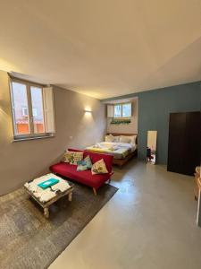 sala de estar con cama y sofá rojo en La casa di zoe, en Roma