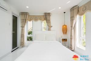 a white bed in a room with windows at Sunset Bãi Dâu Hotel Vũng Tàu VT in Vung Tau +32 photos