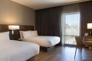 a hotel room with two beds and a window at AC Hotel Kansas City Plaza in Kansas City +8 photos