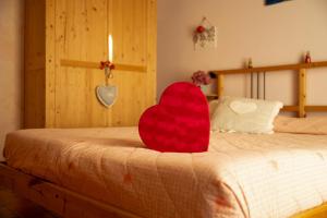 a red heart sitting on top of a bed at Agriturismo Spigolo in Avesa +78 photos