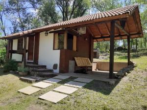 a small cabin with a bench in a yard at Cabañas Franca Austral in Santa Rosa de Calamuchita