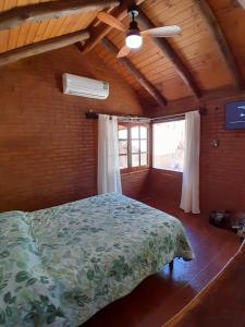 a bedroom with a bed and a ceiling fan at Cabañas Franca Austral in Santa Rosa de Calamuchita