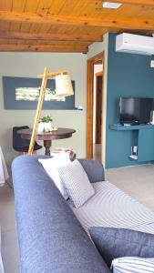 a living room with a blue couch and a table at Casa CRETA - Hermenegildo in Santa Vitória do Palmar +21 photos