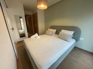 Una cama con sábanas blancas y almohadas en una habitación. en Charmant studio avec vue sur mer, en Rabat 10 fotos más