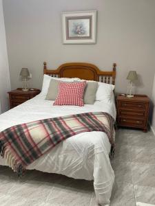 a bedroom with a large bed with two night stands at Alojamiento CasAmalia in Santiago de Cartes