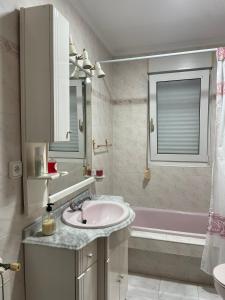 a bathroom with a sink and a bath tub at Alojamiento CasAmalia in Santiago de Cartes +21 photos