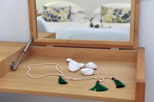 a wooden box with three earrings and a mirror at Apollon Boutique Hotel in Parikia