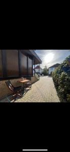 a patio with a table and a bench and a building at Ferienwohnung am Bürgerpark in Bremerhaven +3 photos