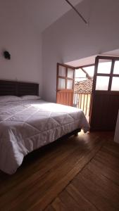 a bedroom with a bed and a large window at Antuquita's House in Cusco