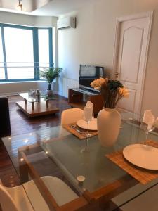 ein Wohnzimmer mit einem Glastisch und einer Vase mit Blumen in der Unterkunft MZA Departamentos in Mendoza