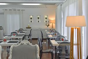a dining room with tables and chairs and a lamp at Apollon Boutique Hotel in Parikia