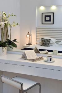 a bedroom with a bed and a table with a book at Apollon Boutique Hotel in Parikia