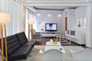 a living room with a couch and a tv at Apollon Boutique Hotel in Parikia