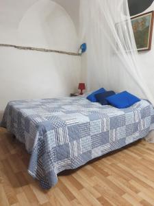 ein Schlafzimmer mit einem Bett mit einer blau-weißen Decke in der Unterkunft Casa di ingrida Bussana Vecchia in Sanremo