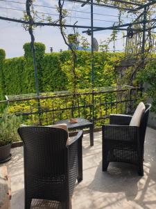 zwei Stühle und ein Tisch auf einer Terrasse in der Unterkunft Casa di ingrida Bussana Vecchia in Sanremo