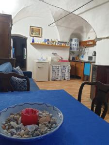 ein blauer Tisch mit einer Schale mit Muscheln darauf in der Unterkunft Casa di ingrida Bussana Vecchia in Sanremo
