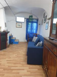 ein Wohnzimmer mit einem blauen Sofa und blauen Vorhängen in der Unterkunft Casa di ingrida Bussana Vecchia in Sanremo + 6 Fotos