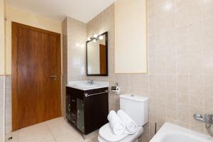 a bathroom with a toilet and a sink and a mirror at Villa Pla de l Era in Salou