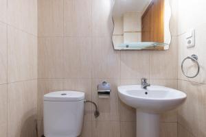 a bathroom with a toilet and a sink and a mirror at Villa Pla de l Era in Salou