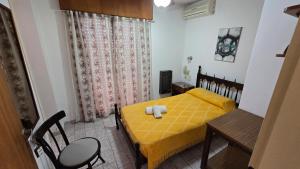 a bedroom with a yellow bed and a chair at Hotel San Martin in Villa María