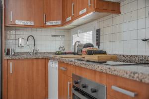 a kitchen with wooden cabinets and a counter top at Rooms City in San Isidro +27 photos