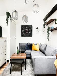 a living room with a couch and a clock on the wall at Apartment Premium Jacuzzi, Old Town Cracow in Kraków