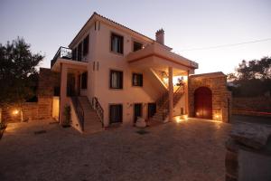 a large house with a driveway in front of it at Avgerinos Hotel in Kambos