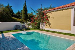 une piscine dans l'arrière-cour d'une maison dans l'établissement Villa Penelope Periyali, à Vasilikos